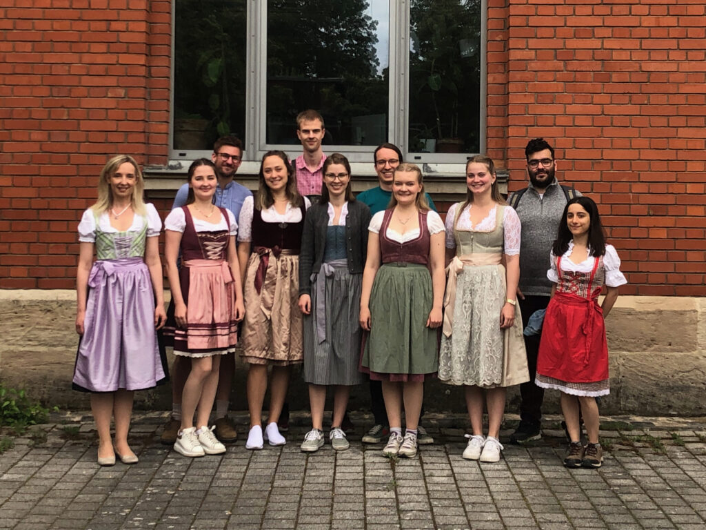 BVT representation wearing traditional clothing in front of red brick building