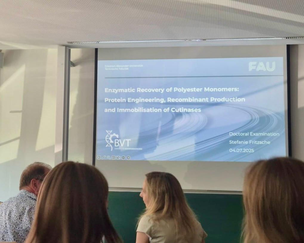 Seminar room with the view on the first slide of the presentation and four paricipants