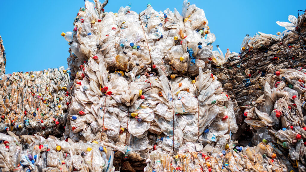 Multiple cubes of compressed plastic garbage near the waste recycling factory in open air